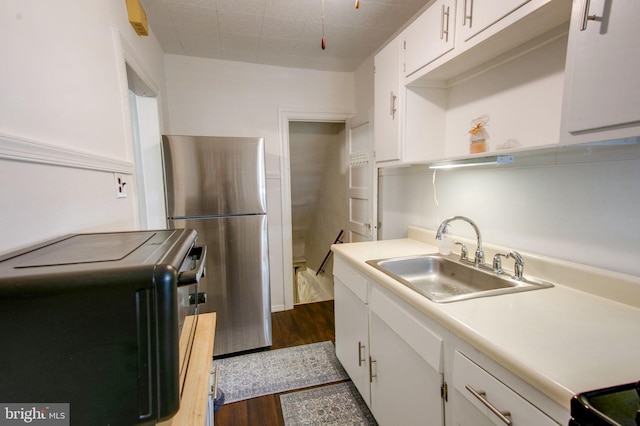 kitchen with stainless steel refrigerator, sink, white cabinets, and dark hardwood / wood-style floors