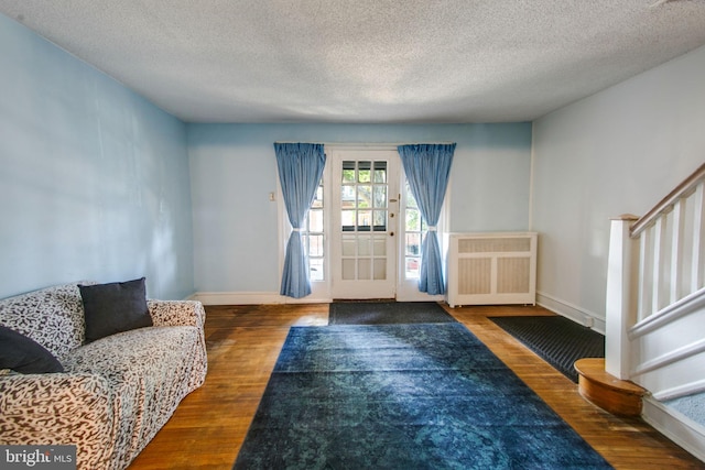 entryway featuring dark hardwood / wood-style flooring, a textured ceiling, and radiator heating unit