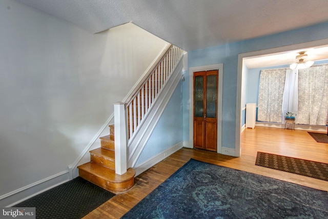 stairs featuring hardwood / wood-style floors