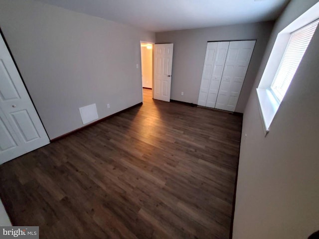 unfurnished bedroom with dark hardwood / wood-style floors