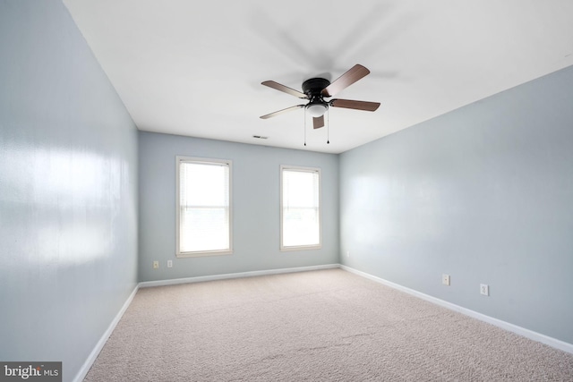 carpeted spare room featuring ceiling fan