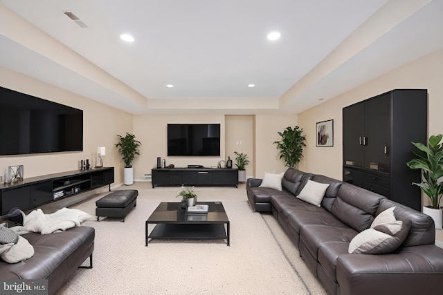 living room featuring a tray ceiling and light carpet