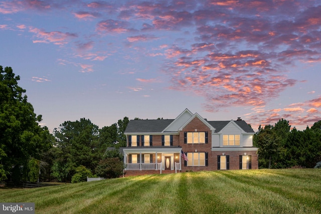 view of front of property featuring a lawn and a porch