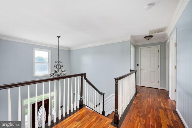 hall featuring a notable chandelier, dark hardwood / wood-style floors, and ornamental molding