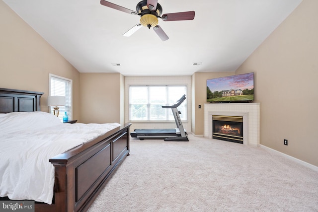 bedroom featuring ceiling fan, vaulted ceiling, light carpet, and multiple windows