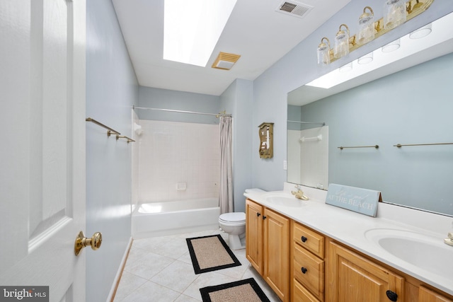 full bathroom with vanity, tile patterned floors, shower / bath combination with curtain, a skylight, and toilet