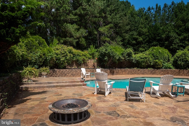 view of swimming pool featuring a fire pit and a patio