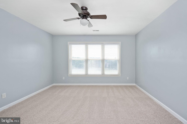 spare room with ceiling fan and light colored carpet