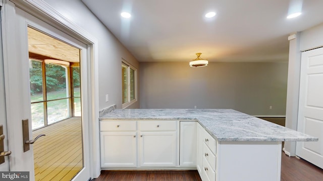 kitchen with white cabinetry, kitchen peninsula, and light stone counters