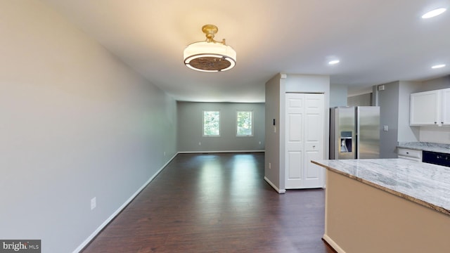 kitchen featuring light stone counters, white cabinetry, stainless steel fridge, and dark hardwood / wood-style flooring