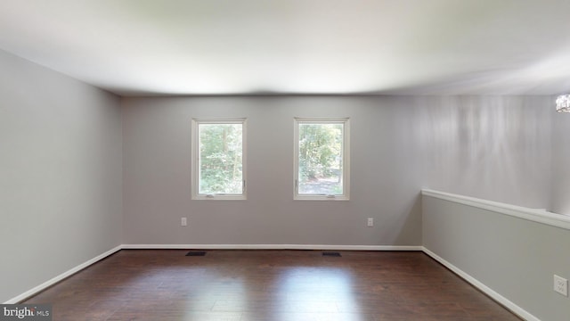 spare room with dark wood-type flooring