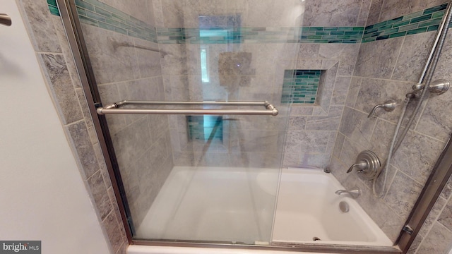 bathroom with bath / shower combo with glass door