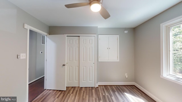 unfurnished bedroom featuring hardwood / wood-style flooring, ceiling fan, and a closet