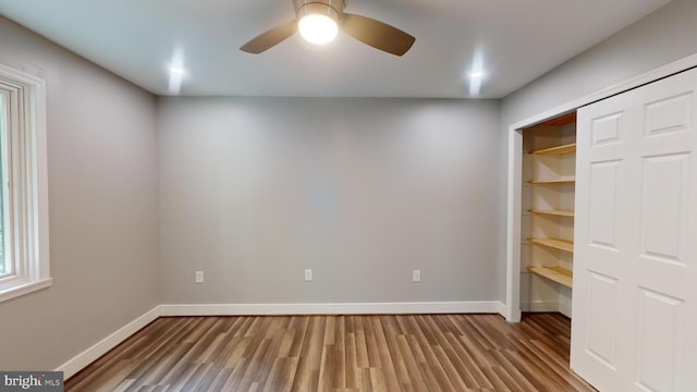 unfurnished bedroom featuring ceiling fan, wood-type flooring, and a closet