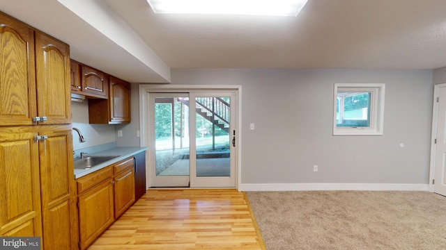 kitchen with sink, light hardwood / wood-style flooring, and a textured ceiling