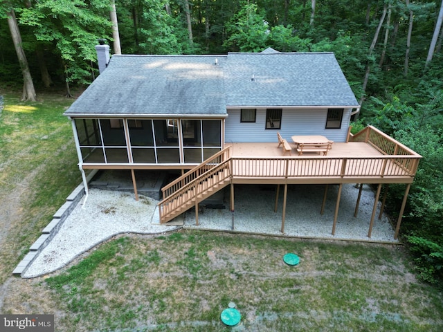 rear view of house featuring a jacuzzi, a deck, and a sunroom