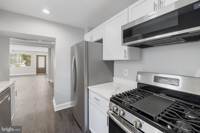 kitchen with white cabinetry, dark hardwood / wood-style flooring, light stone counters, and appliances with stainless steel finishes