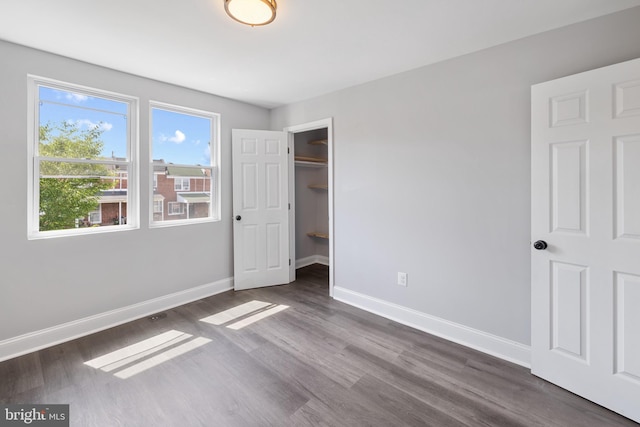 unfurnished bedroom featuring dark hardwood / wood-style flooring and a closet