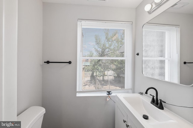 bathroom featuring vanity, toilet, and a wealth of natural light