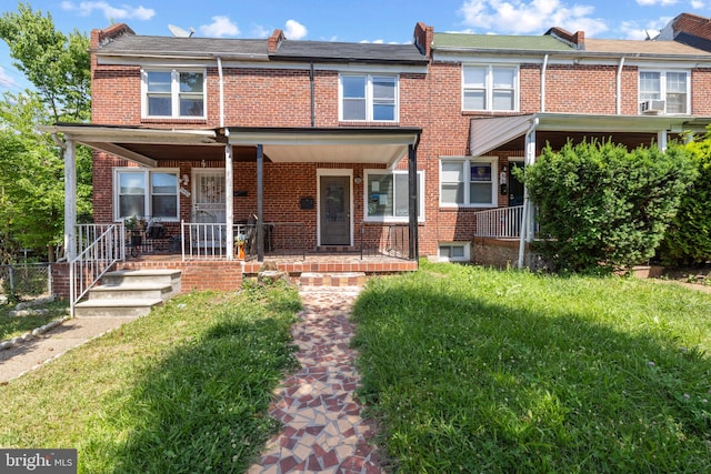 multi unit property with a front lawn and covered porch