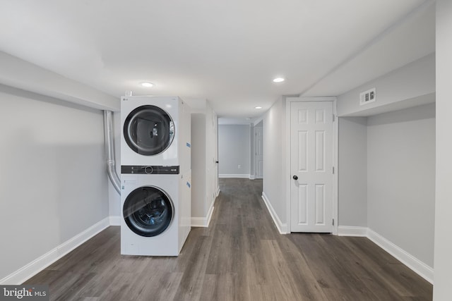 washroom featuring stacked washer and dryer and dark hardwood / wood-style floors