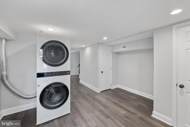 laundry room with stacked washer / dryer and dark wood-type flooring