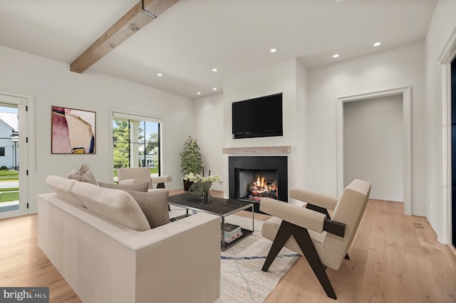 living room with beam ceiling and light hardwood / wood-style flooring