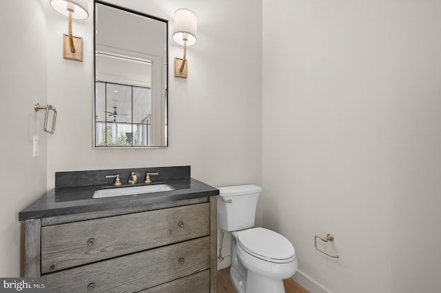 bathroom with hardwood / wood-style floors, vanity, and toilet