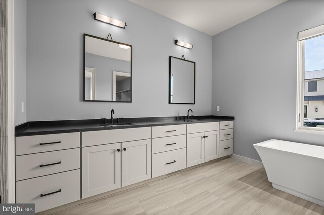 bathroom featuring a bathtub, vanity, and hardwood / wood-style flooring