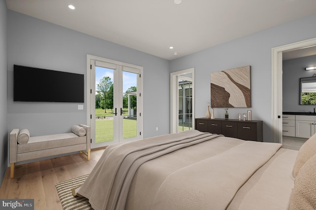 bedroom with light hardwood / wood-style floors, access to exterior, and connected bathroom