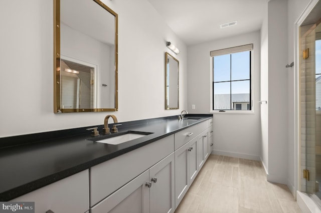 bathroom with a shower with door and vanity