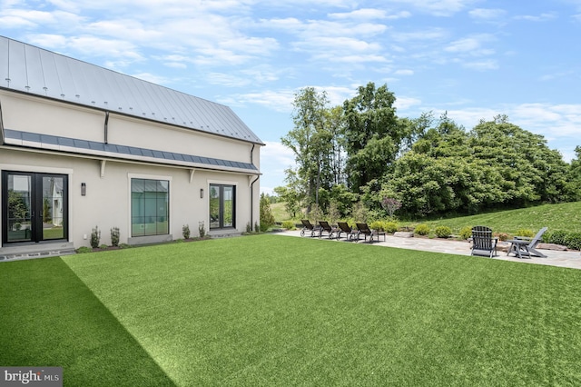 view of yard featuring a patio area, french doors, and a fire pit