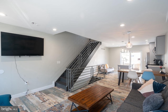 living room featuring sink and light hardwood / wood-style flooring