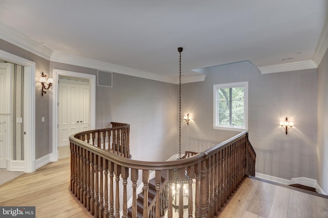 hall with light wood-type flooring and ornamental molding