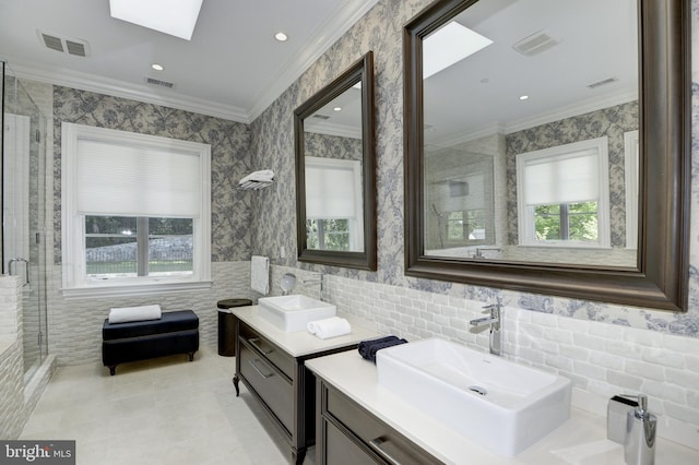 bathroom with a wealth of natural light, a skylight, an enclosed shower, and vanity