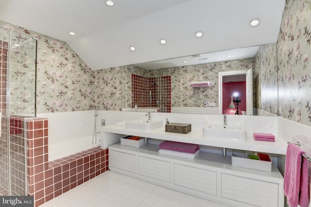 bathroom with plus walk in shower, lofted ceiling, vanity, and tile patterned floors