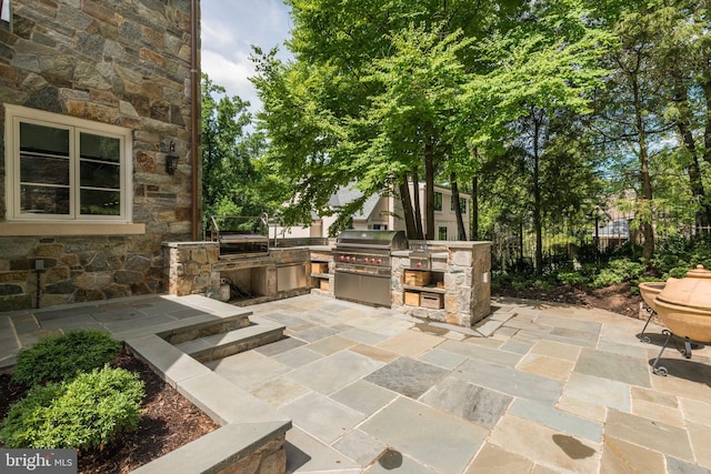 view of patio featuring an outdoor kitchen and a grill