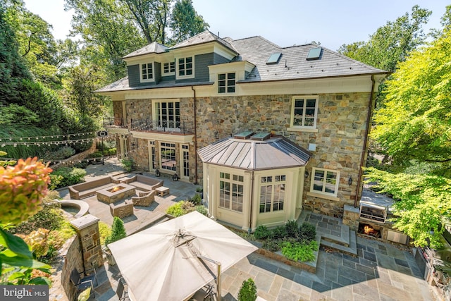 back of property with a patio and a fire pit