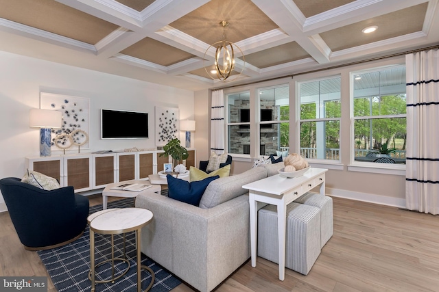 living room with wood-type flooring, ornamental molding, a notable chandelier, and coffered ceiling