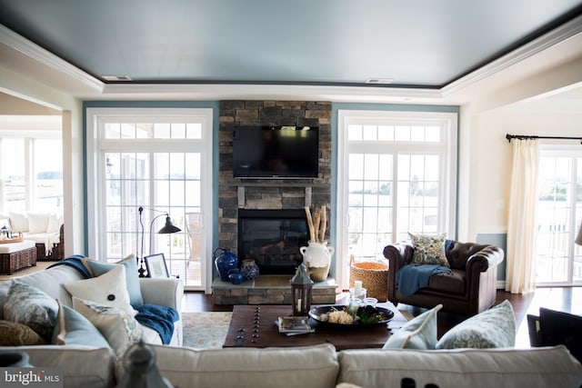 living room featuring hardwood / wood-style flooring, crown molding, and a fireplace