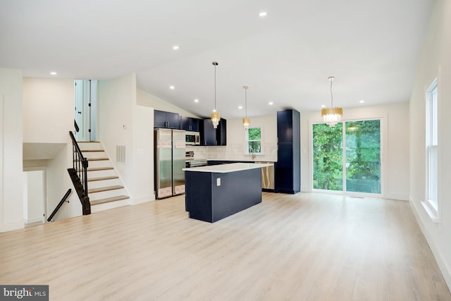 kitchen with pendant lighting, a center island, light hardwood / wood-style flooring, tasteful backsplash, and stainless steel appliances