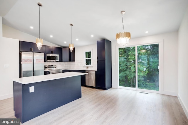 kitchen with appliances with stainless steel finishes, light hardwood / wood-style flooring, hanging light fixtures, and lofted ceiling