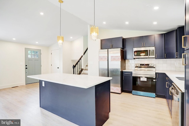 kitchen featuring tasteful backsplash, light hardwood / wood-style floors, pendant lighting, lofted ceiling, and appliances with stainless steel finishes