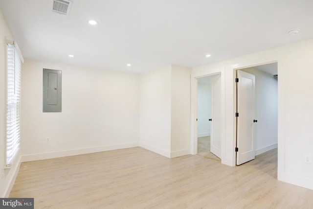 unfurnished room with light wood-type flooring and electric panel