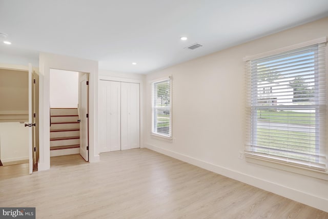 unfurnished bedroom featuring light hardwood / wood-style flooring and a closet