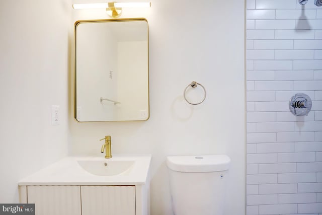 bathroom featuring vanity, toilet, and tiled shower