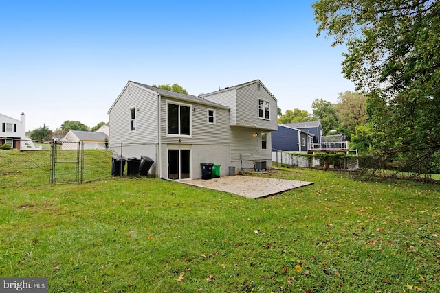 rear view of house with a yard, cooling unit, and a patio area