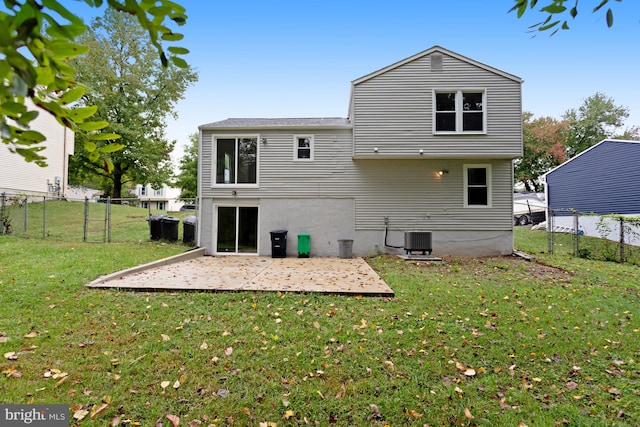 back of property featuring central AC unit and a yard