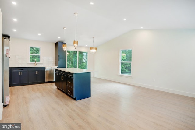 kitchen with appliances with stainless steel finishes, a kitchen island, hanging light fixtures, and a wealth of natural light