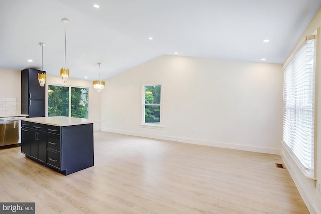 kitchen with lofted ceiling, stainless steel dishwasher, light hardwood / wood-style floors, decorative light fixtures, and a kitchen island